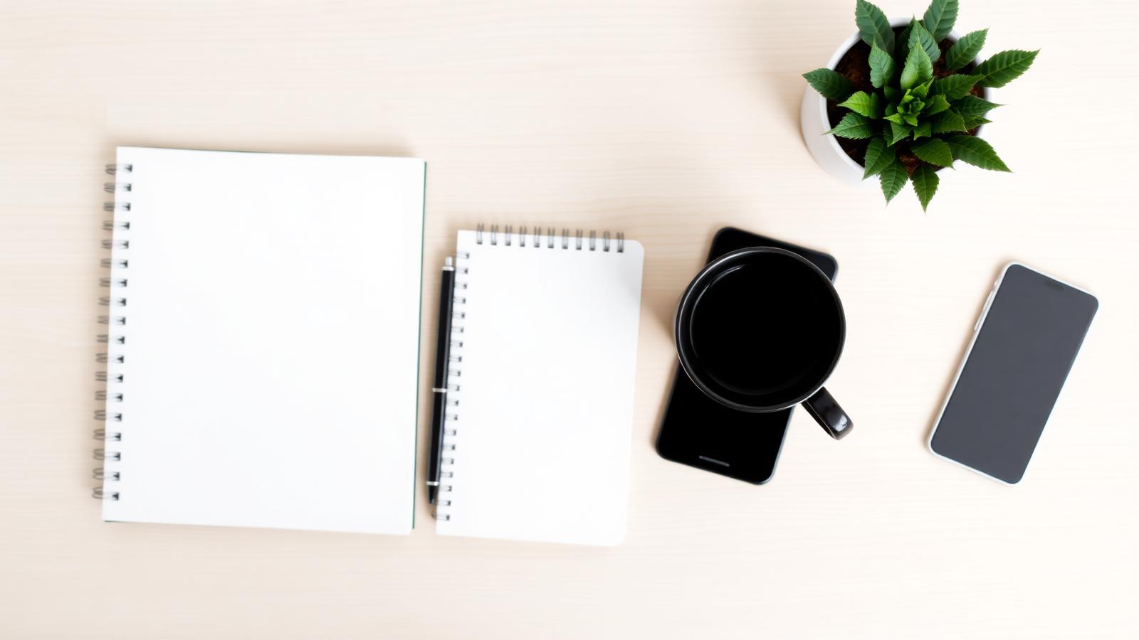 Notebook, coffee and phone on a desk
